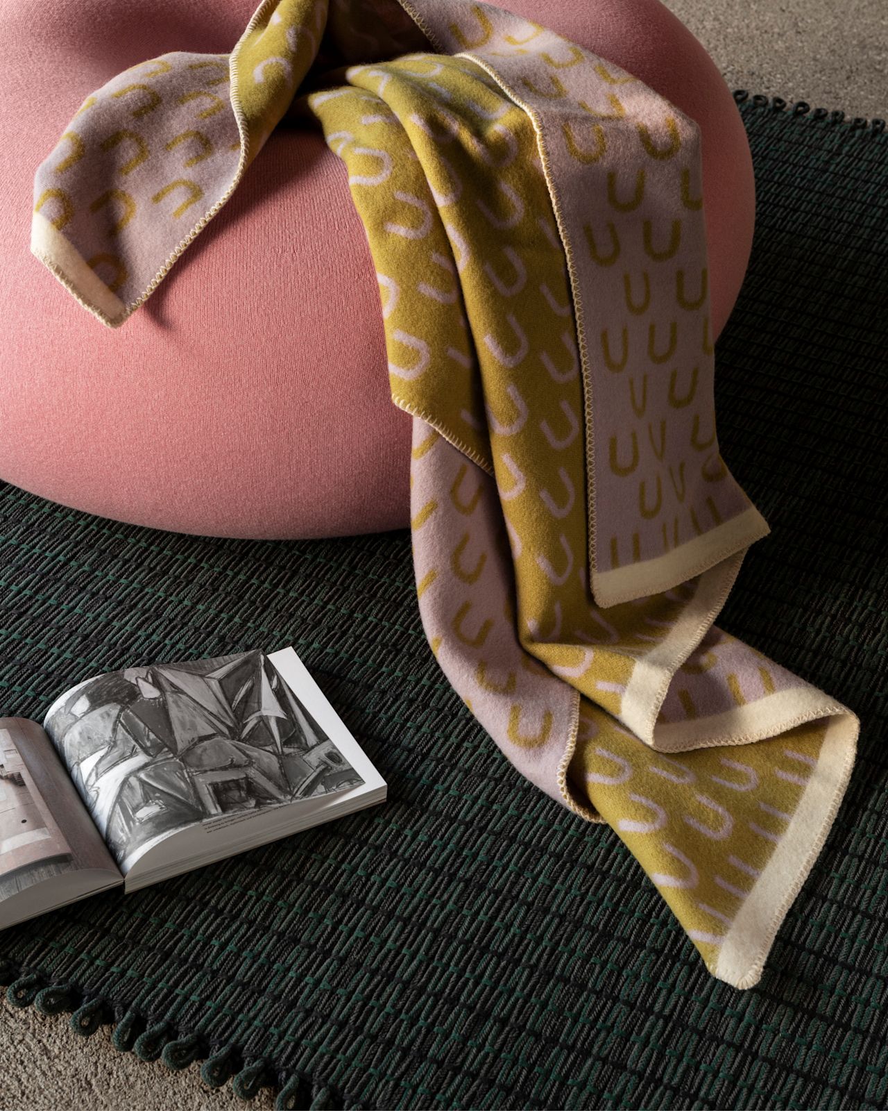 A lifestyle image of a lounge scene featuring Rope Rug, Arch Throw, and Boa Pouf.