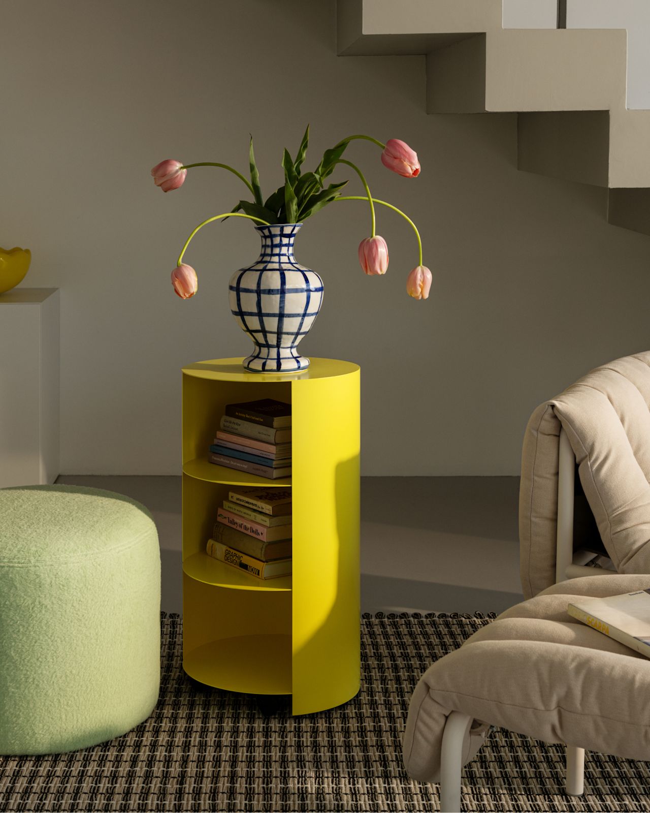 A lifestyle image of a lounge scene featuring Hide Pedestal, Rope Rug, and Bon Pouf Round.