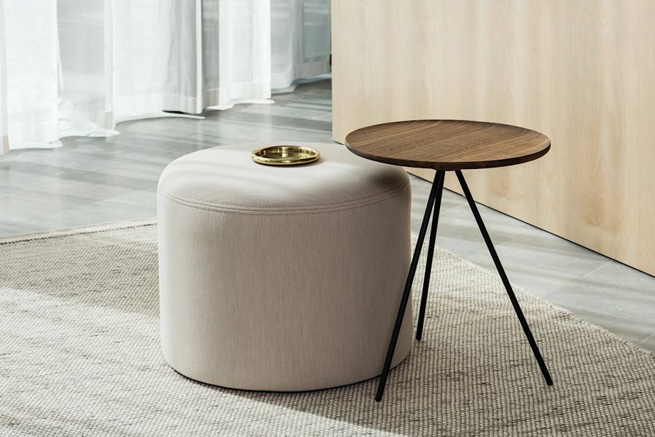A lifestyle image of a lounge scene featuring Bon Pouf Round and Key Side Table.