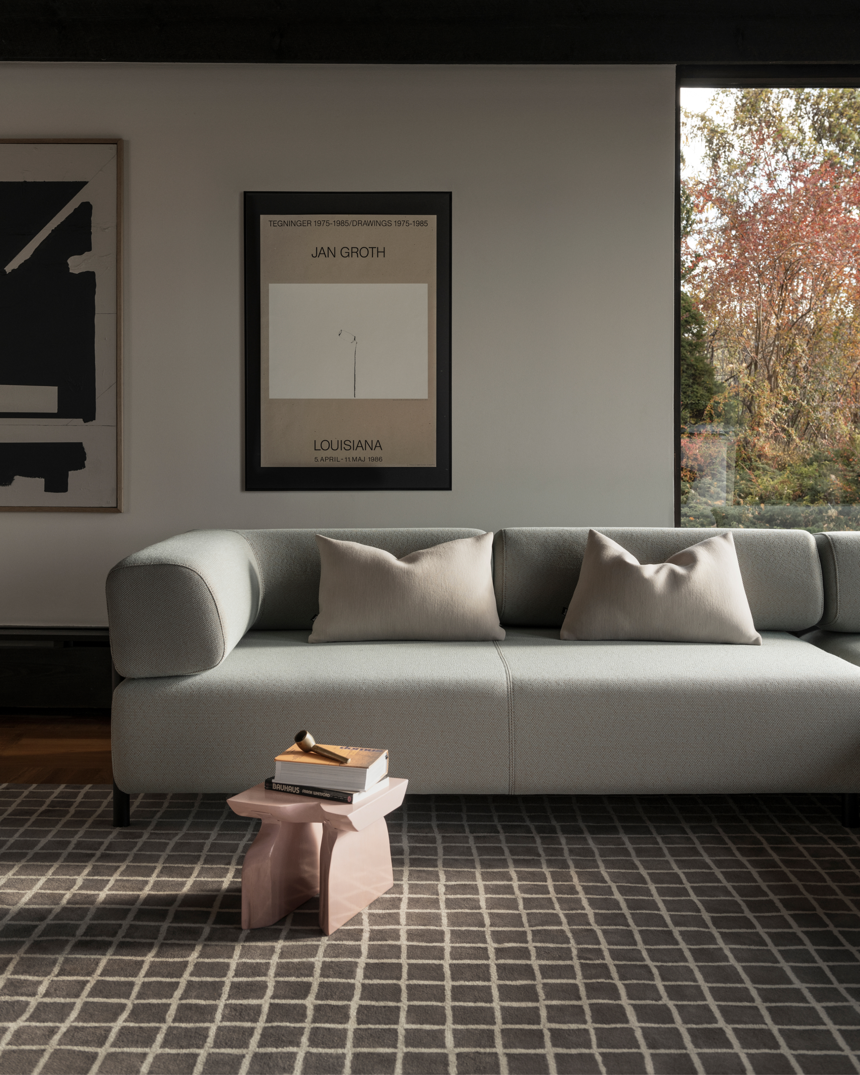 A lifestyle image of a living room/lounge scene featuring Grid Rug Large, Palo Modular Sofa, and Neo Cushions.