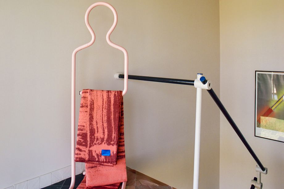 A lifestyle image of a hallway/entryway featuring Glitch Throw Coral / Rust Red.