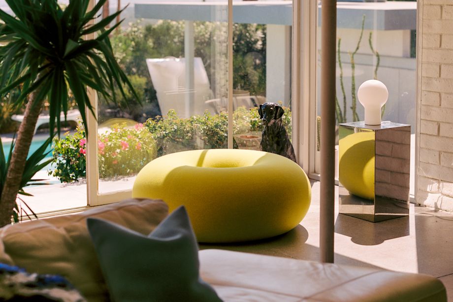 A lifestyle image of a lounge scene featuring Boa Pouf, Coco Table Lamp, and Velvet Cushion Medium.