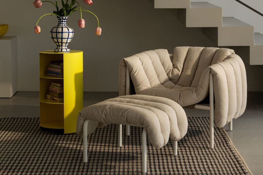 A lifestyle image of a lounge scene featuring Puffy Lounge Chair + Ottoman, Rope Rug and Hide Pedestal.