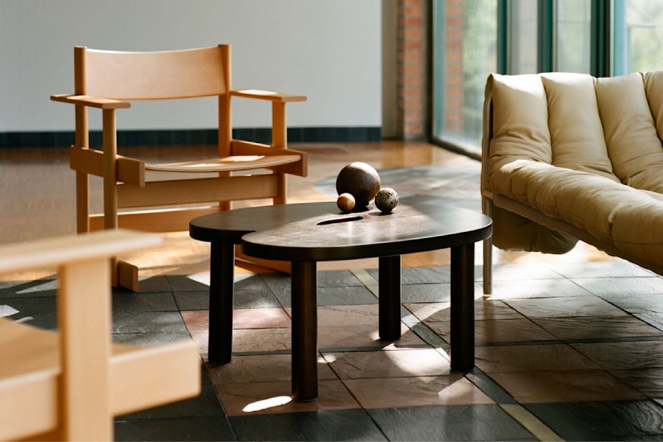 A lifestyle image of a lounge scene featuring Bullnose Lounge Chair, Worm Coffee Table, and Puffy Sofa.
