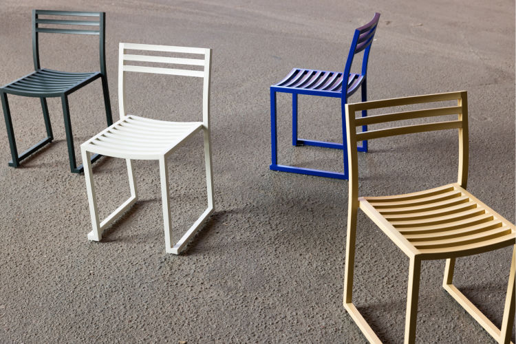 An editorial image from behind the scenes with Philippe Malouin, the designer of Chop Chair and Chop Tables, featuring the Chop Chairs in 4 powder-coated colorways.