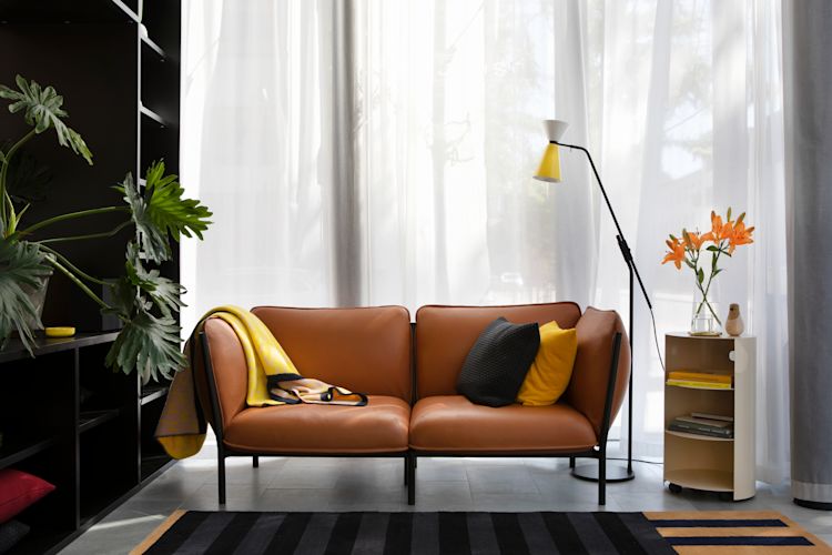 A lifestyle image from the Hem Headquarters in Stockholm, Sweden featuring Kumo Sofa, Hide Pedestal, Alphabeta Floor Lamp, Strip Rug, Dash Cushion, and Arch Throw. From 2018.