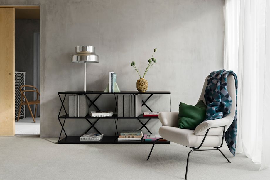 A lifestyle image of a living room scene featuring Hai Lounge Chair, Vienna Throw, and Lift Shelf.