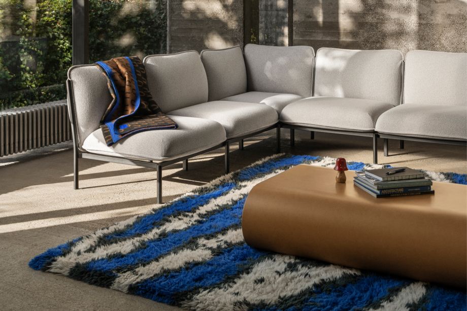 Hem - A living room scene featuring Kumo Sofa in Porcelain, Arch Throw Black / Brown / Blue, Monster Rug Ultramarine / Off-White, and Stump Coffee Table Medium Natural.