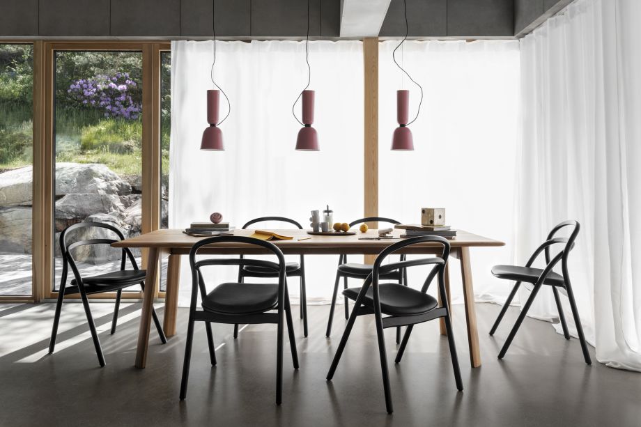 A lifestyle image of a dining scene featuring Alphabeta Pendant Lights, Udon Upholstered Chairs, and Alle Table.