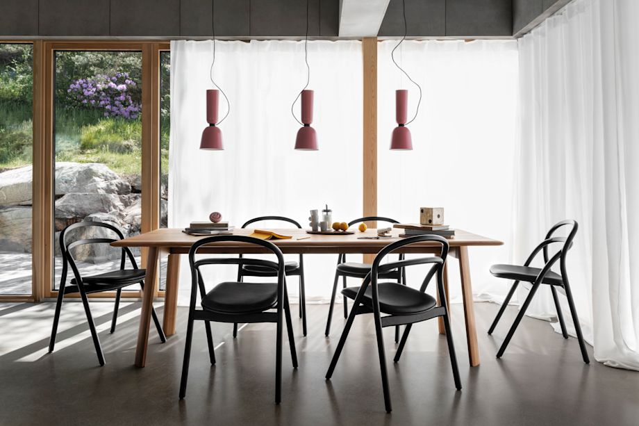 A lifestyle image of a dining scene featuring Alphabeta Pendant Lights, Udon Upholstered Chairs, and Alle Table.
