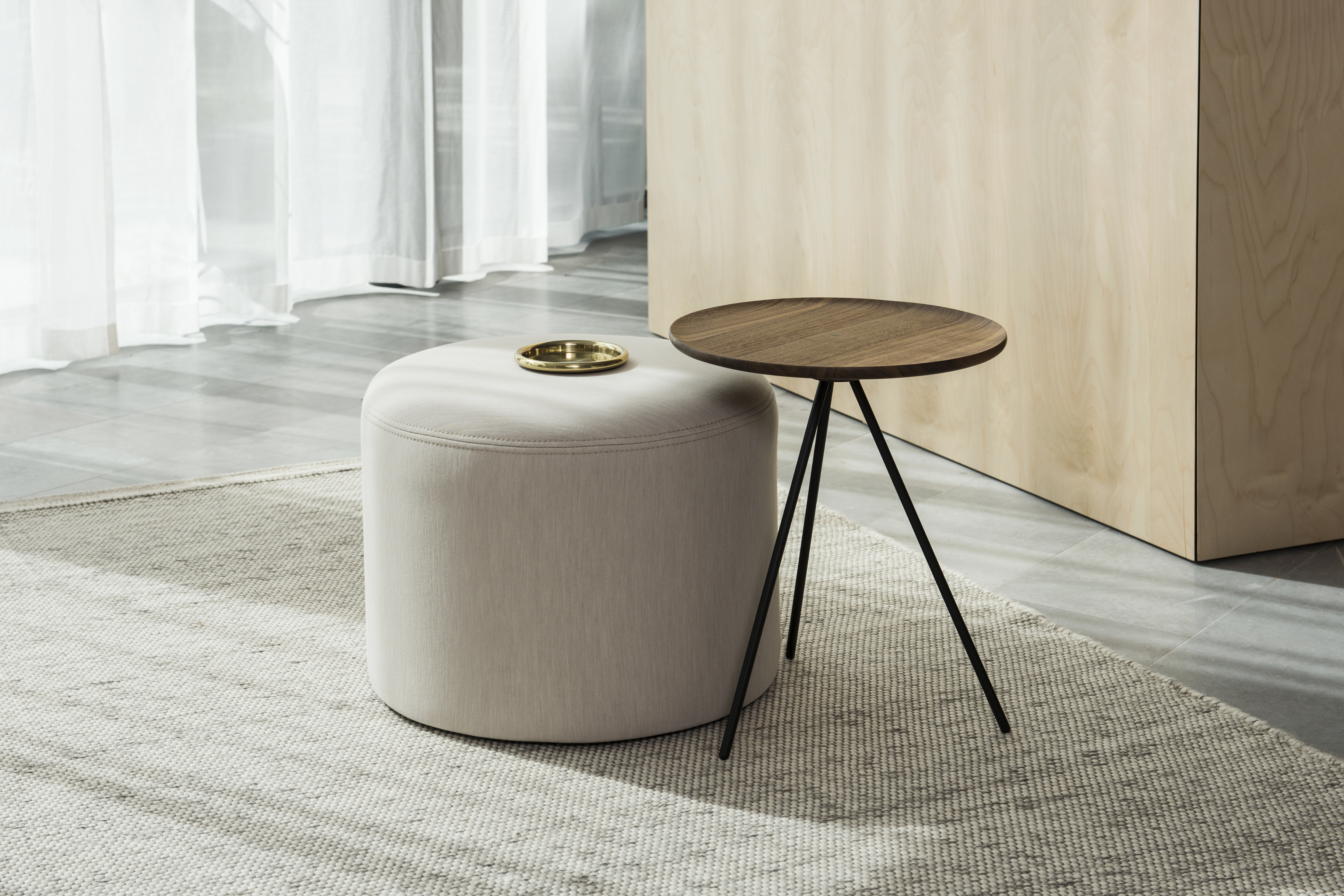 A lifestyle image of a lounge scene featuring Bon Pouf Round and Key Side Table.