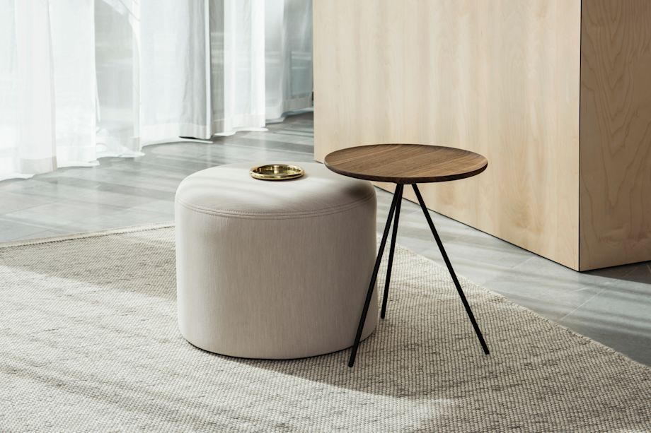 A lifestyle image of a lounge scene featuring Bon Pouf Round and Key Side Table.