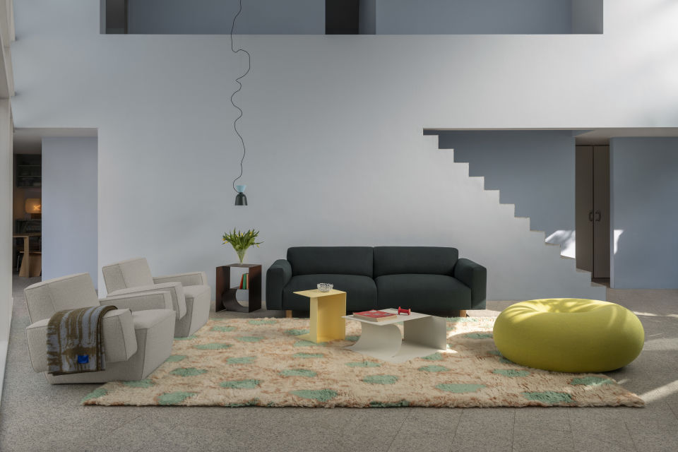 A lifestyle image of a living room scene featuring Hunk Lounge Chair, Monster Rug, Glitch Throw, Alphabeta Pendant Light, Glyph Side Tables, Boa Pouf and Koti Sofa.