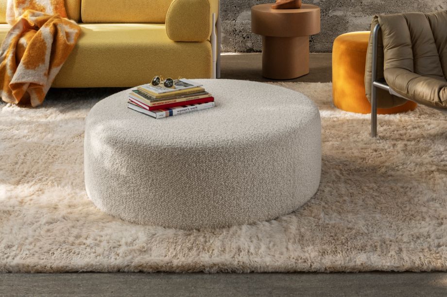 Hem - A living room scene featuring a Bon Pouf Round Large in Eggshell with books placed on top of it.