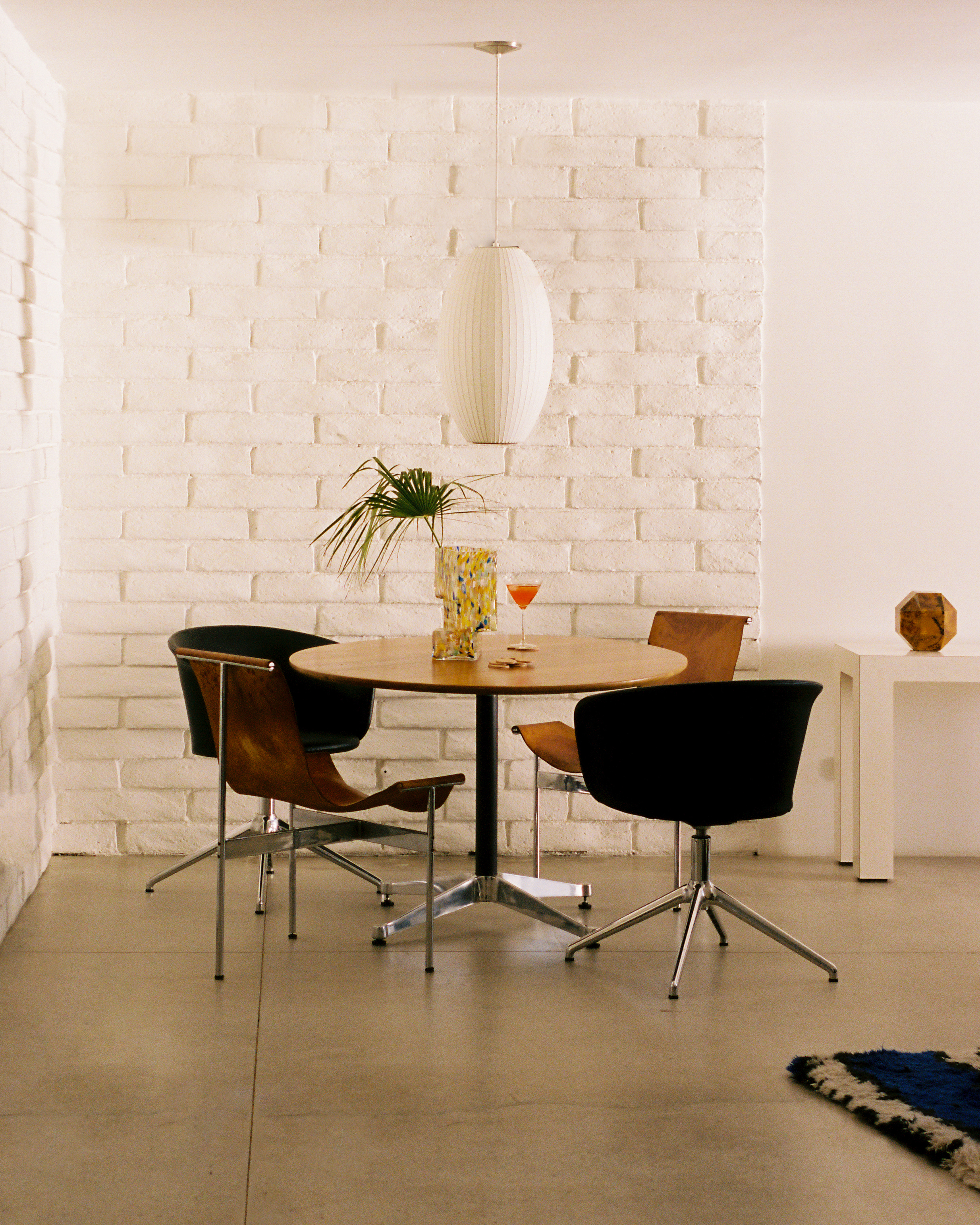 A lifestyle image of a dining scene featuring Kendo Swivel Chairs, Disco Coasters, and Brute Vase.
