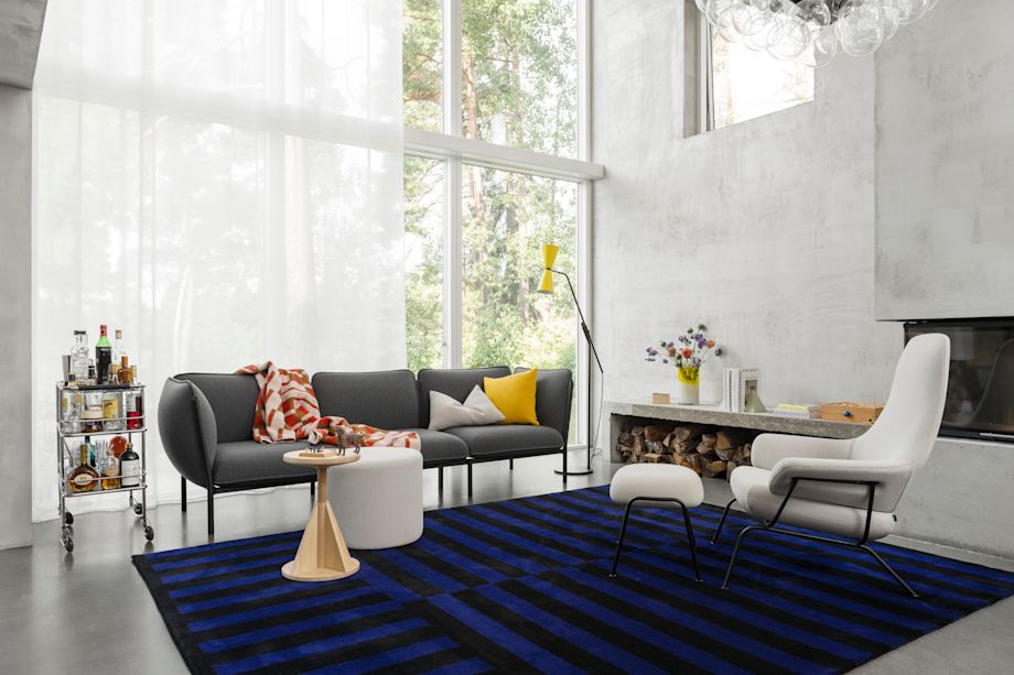 Living room setting with Kumo sofa in Graphite, Hai Lounge Chair and Ottoman, Bon Pouf, All Wood Rocket Stool, Stripe Rug, Vienna Throw, and Alphabeta Floor lamp.