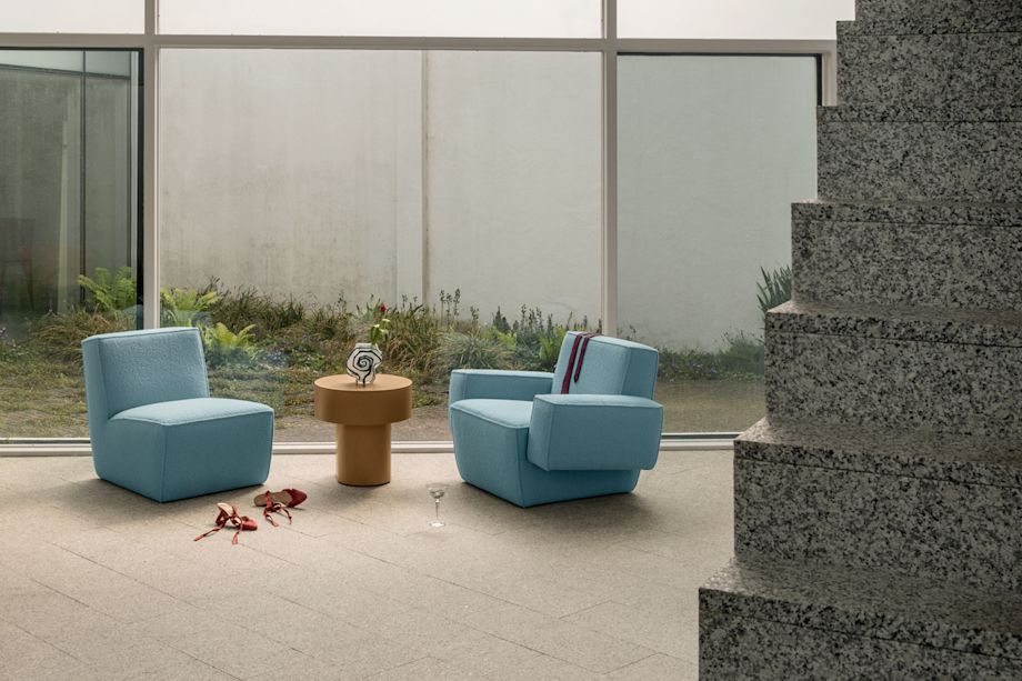 A lifestyle image of a lounge scene featuring Hunk Lounge Chair, Hunk Lounge Chair with Armrests, and Stump Side Table.