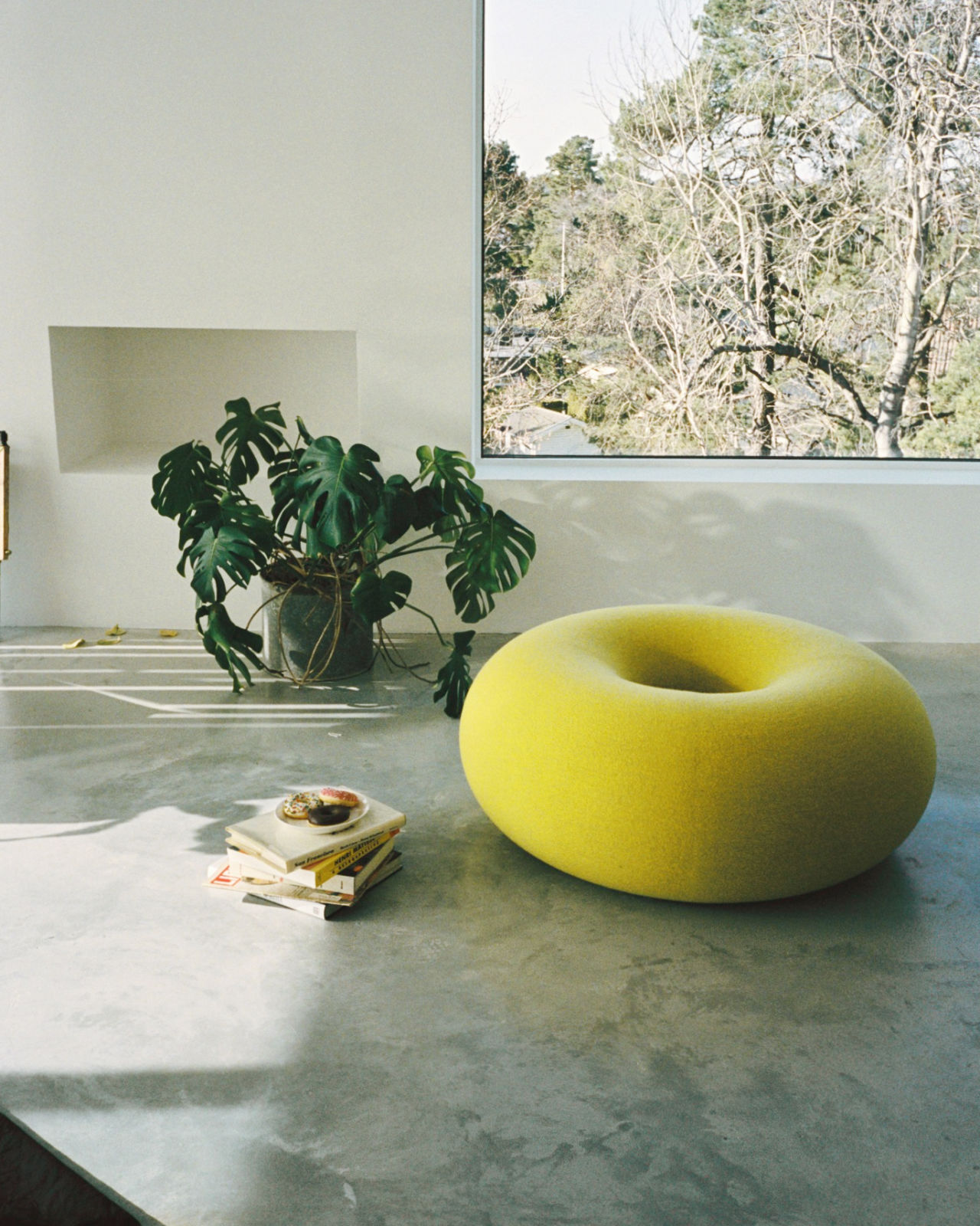 An analog image of a lounge scene featuring Boa Pouf Sulfur Yellow.