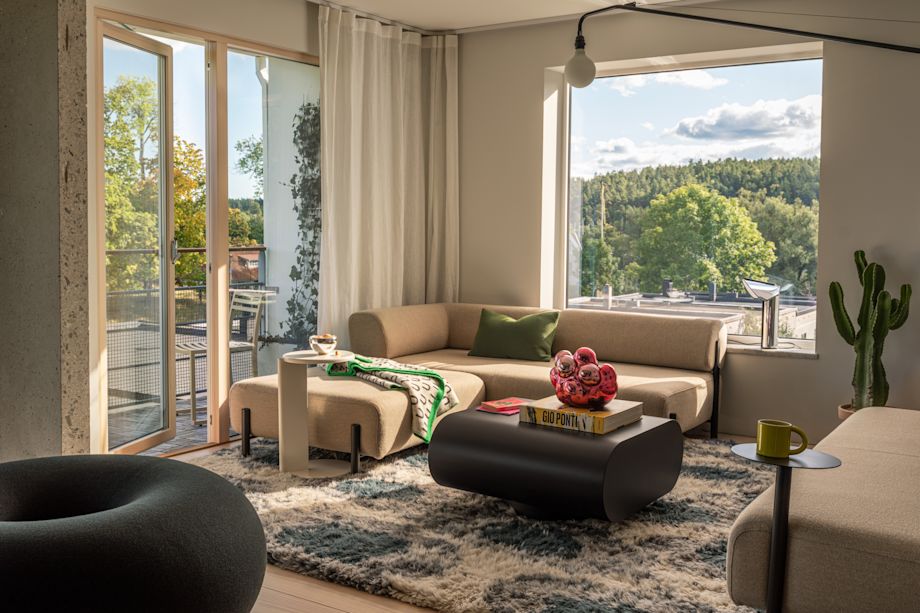 A lifestyle image of a living room scene featuring Palo Modular Sofa, Lolly Side Table, Stump Coffee Table Medium, Boa Pouf, Moln, Arch Throw, Neo Cushion Large, Monster Rug, and Bronto Mug.