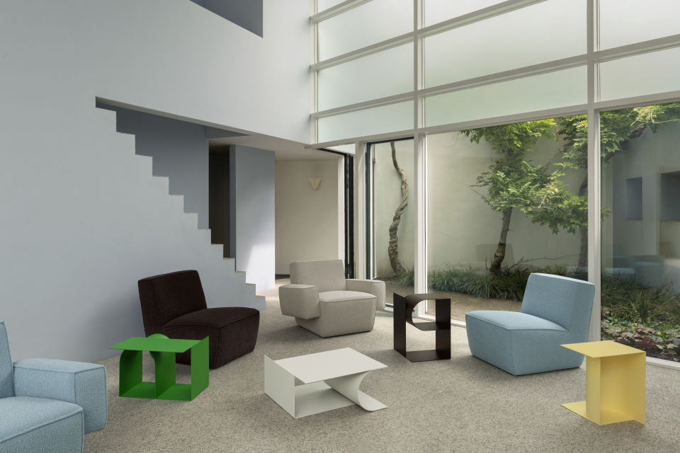 A lifestyle image of Hunk Lounge Chair, Hunk Lounge Chair with Armrests, and Glyph Side Tables Alpha, Beta and Gamma.