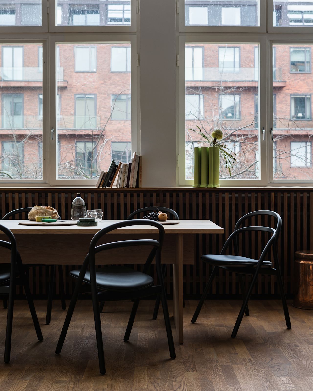 A lifestyle image of a dining scene featuring Bookmatch Table and Udon Chairs.