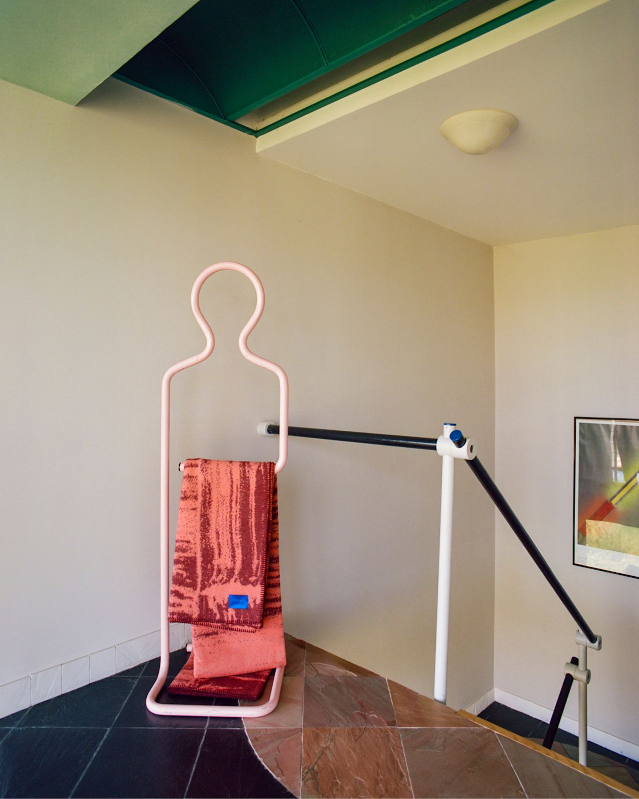 A lifestyle image of a hallway scene featuring Glitch Throw Coral / Rust Red.
