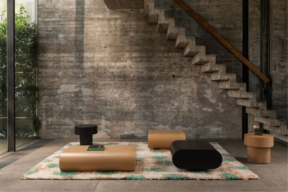 A lifestyle image featuring Stump Coffee Tables, Stump Side Tables, and Monster Rug.