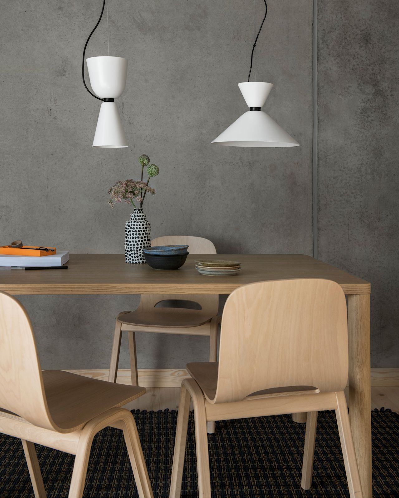 A lifestyle image of a dining scene featuring Alphabeta Pendant Lights, Log Table, Touchwood Chairs, and Rope Rug.