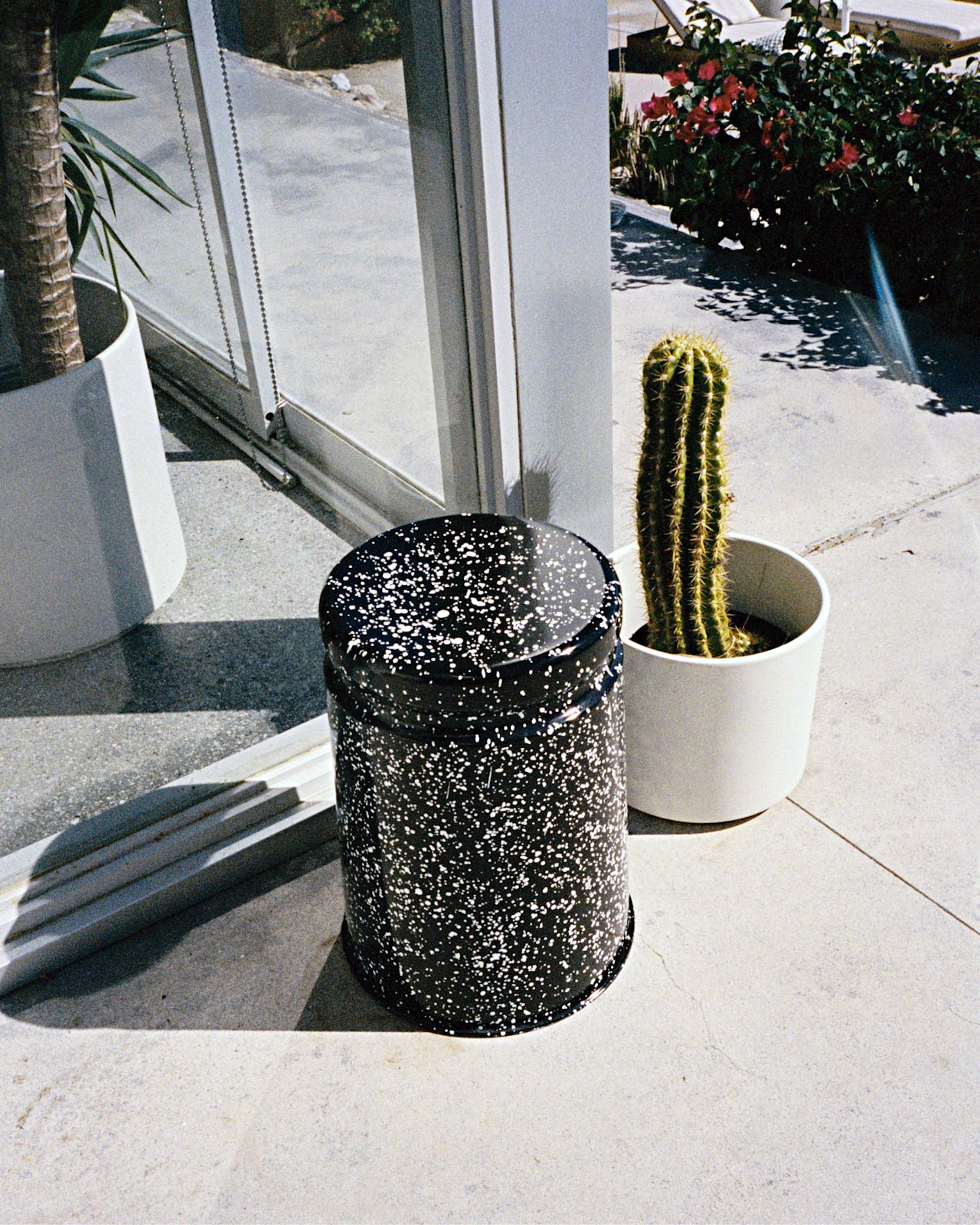 A lifestyle image of a patio scene featuring Last Stool Black / White Splatter.