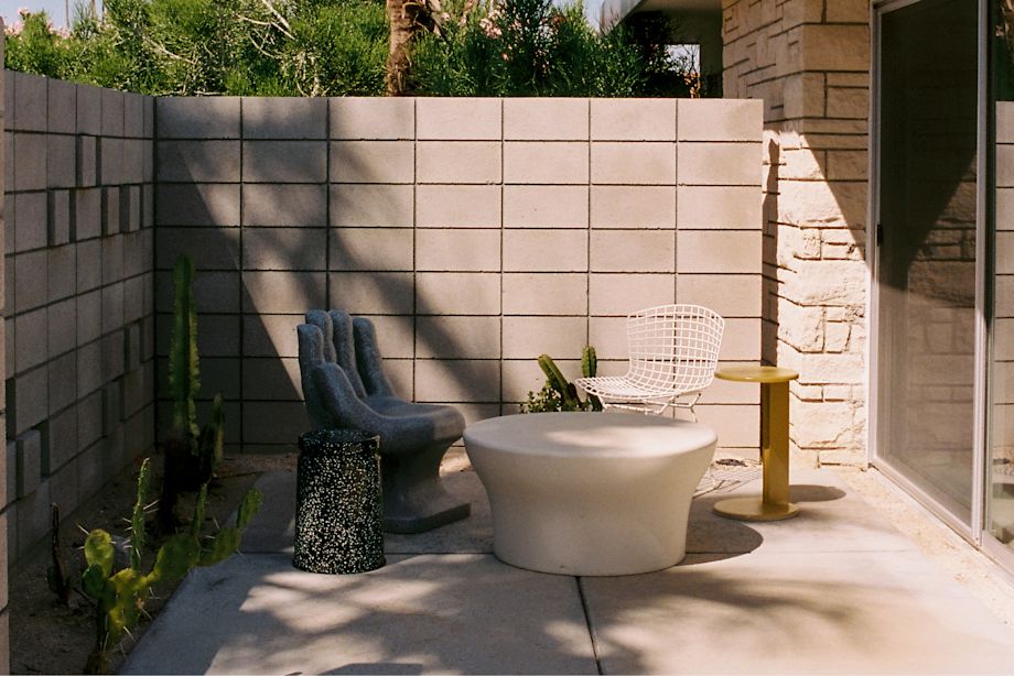 A lifestyle image of an outdoor patio scene featuring Lolly Side Table and Last Stool.
