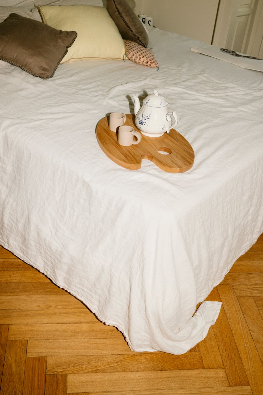 A lifestyle image of a bedroom scene featuring Palette Cutting Board and Bronto Espresso Cups.