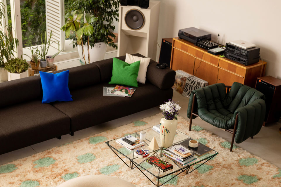 A lifestyle image of a living room scene featuring Palo Modular Sofa, Crepe Cushion, Monster Rug Medium, Puffy Lounge Chair, and Boa Pouf.