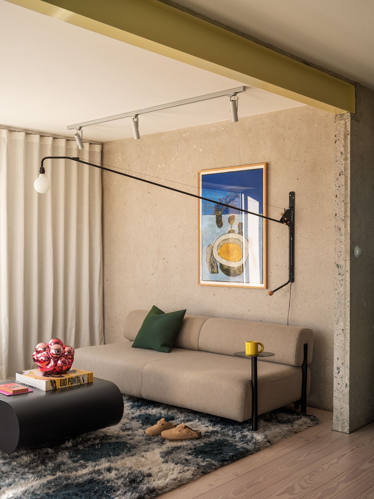 A lifestyle image of a living room scene featuring Palo Modular Sofa, Palo Side Table, Monster Rug, Stump Coffee Table Medium, Neo Cushion Medium, and Bronto Tableware.