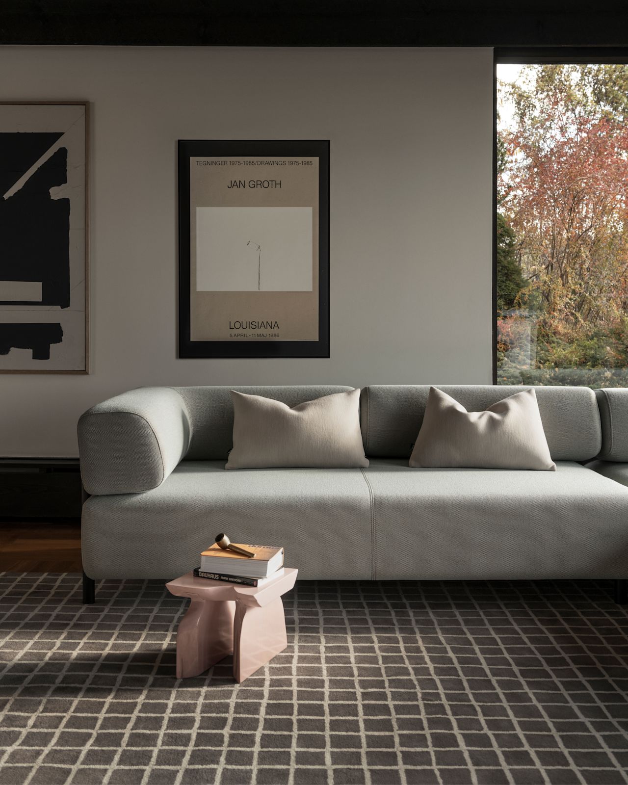 A lifestyle image of a living room scene featuring Palo Modular Sofa, Grid Rug, and Neo Cushions.