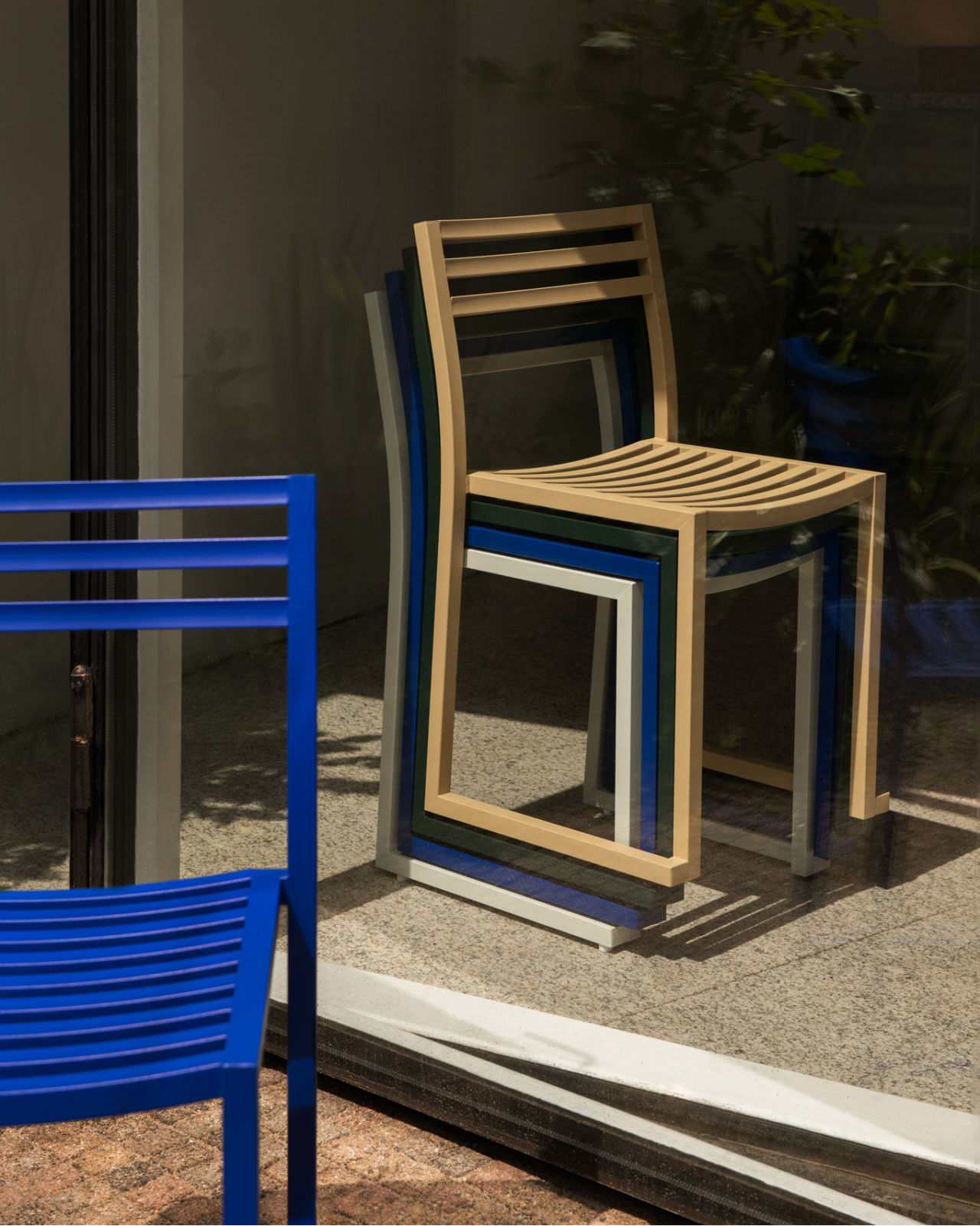 A lifestyle image of an outdoor scene featuring Chop Chairs stacked.