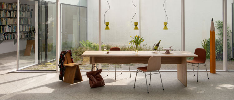 A lifestyle image of a dining scene featuring Bookmatch Table, Touchwood Chairs and Alphabeta Pendant Lights.