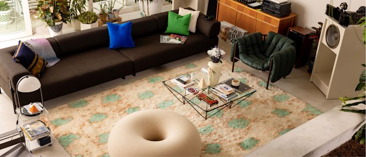 A lifestyle image of a living room scene featuring Palo Modular Sofa, Crepe Cushion, Velvet Cushion Medium, Monster Rug, Boa Pouf, and Puffy Lounge Chair.