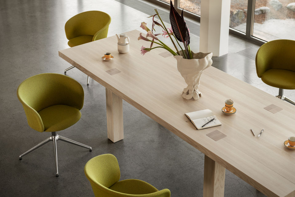 A lifestyle image of an office scene featuring Max Table and Kendo Chairs.