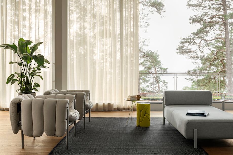 A lifestyle image of a living room / lounge scene featuring Puffy Lounge Chairs, Dune Rug, Key Side Table, and Palo Modular Lounger.