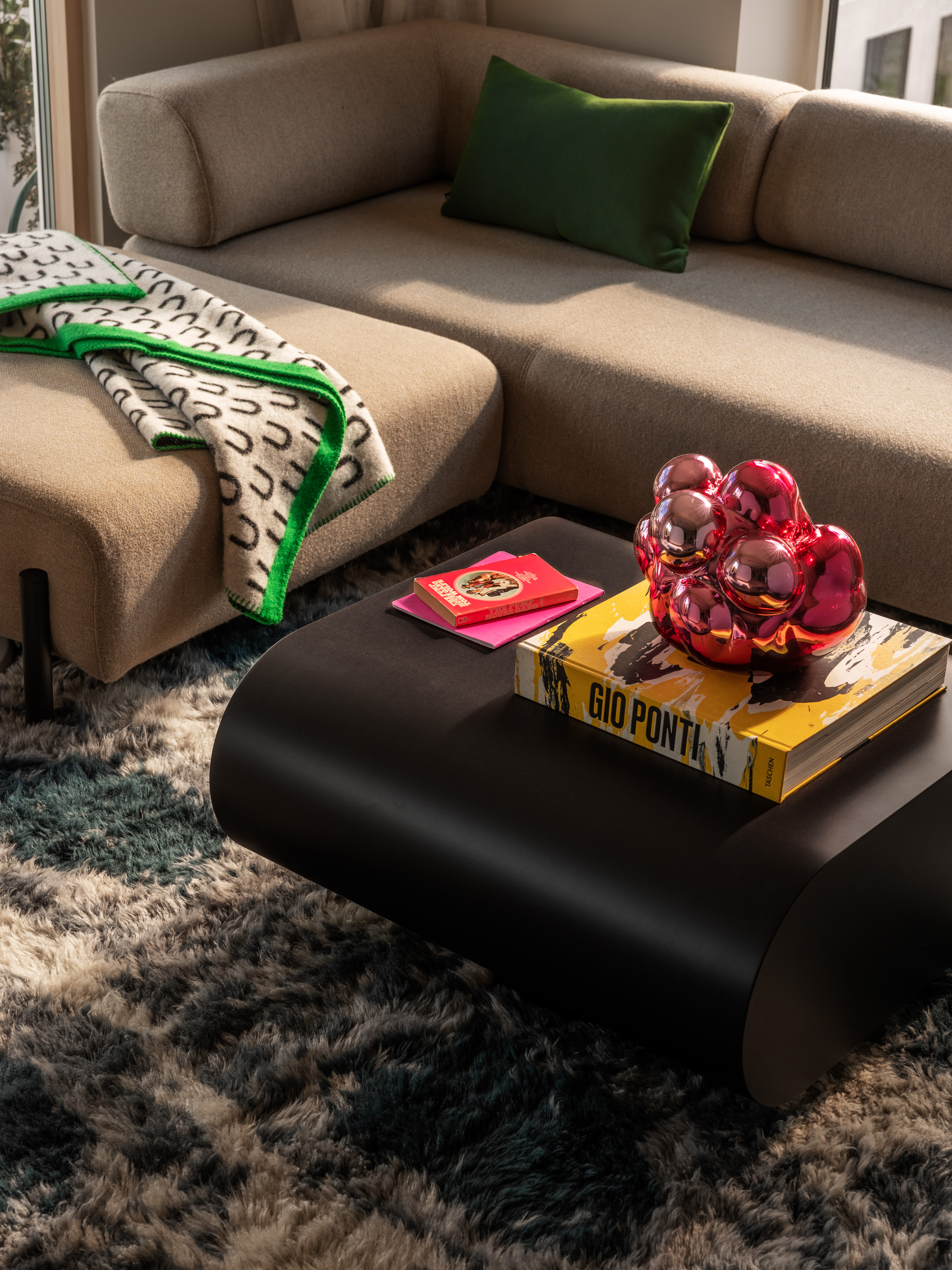 A lifestyle image of a living room scene featuring Palo Modular Sofa, Arch Throw, Lolly Side Table, Monster Rug, Moln, Neo Cushion Large, and Stump Coffee Table Medium.