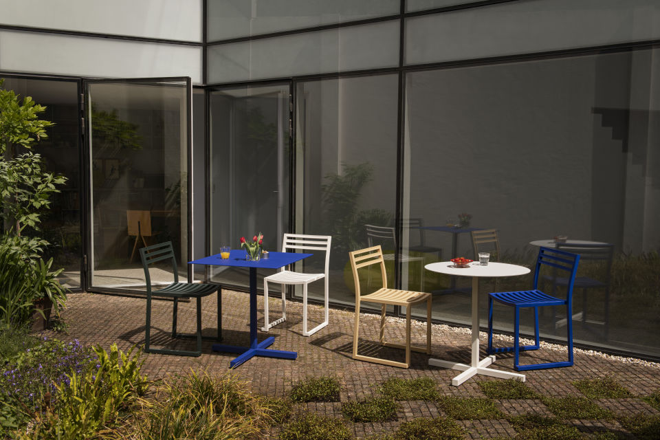 A lifestyle image of a patio scene featuring Chop Tables and Chop Chairs.