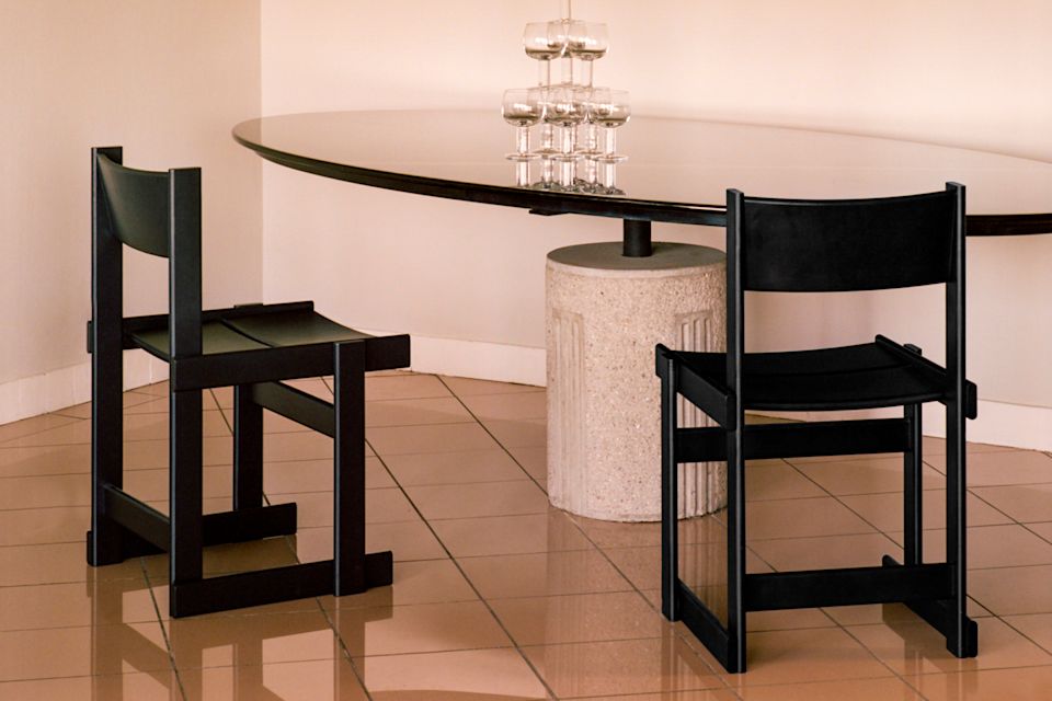 A lifestyle image of a dining scene featuring Bullnose Dining Chairs and Fars Glas.