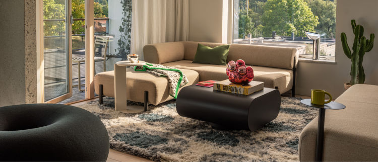 A lifestyle image of a living room / lounge scene featuring Palo Modular Sofa, Chop Dining Chair, Boa Pouf, Lolly Side Table, Arch Throw, Monster Rug, Neo Cushion Large, Stump Coffee Table Medium, Moln, Bronto Mug, Palo Side Table, and more.