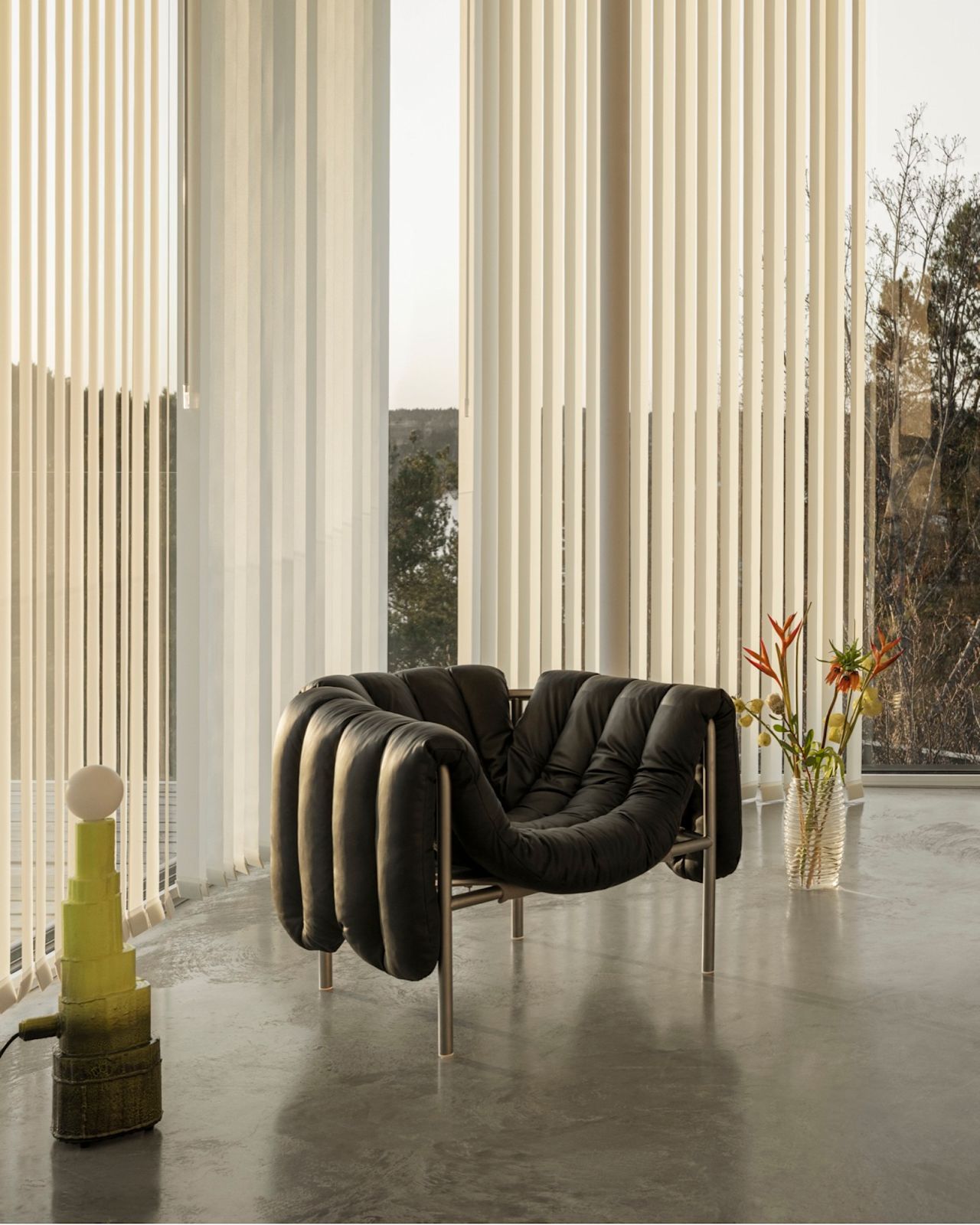 Hem - A lounge scene featuring Puffy Lounge Chair in Black Leather / Stainless.