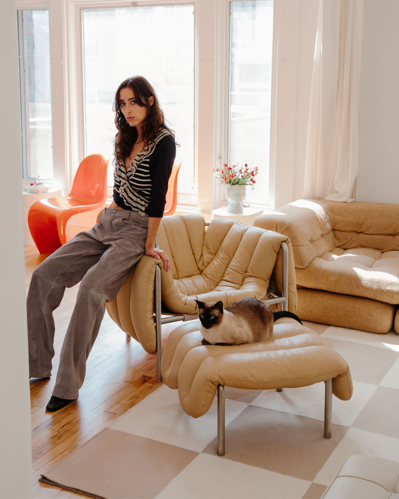 Chloe and her feline friend resting on [Puffy Lounge Chair + Ottoman Sand / Stainless](/furniture/chairs-and-stools/puffy/20309)