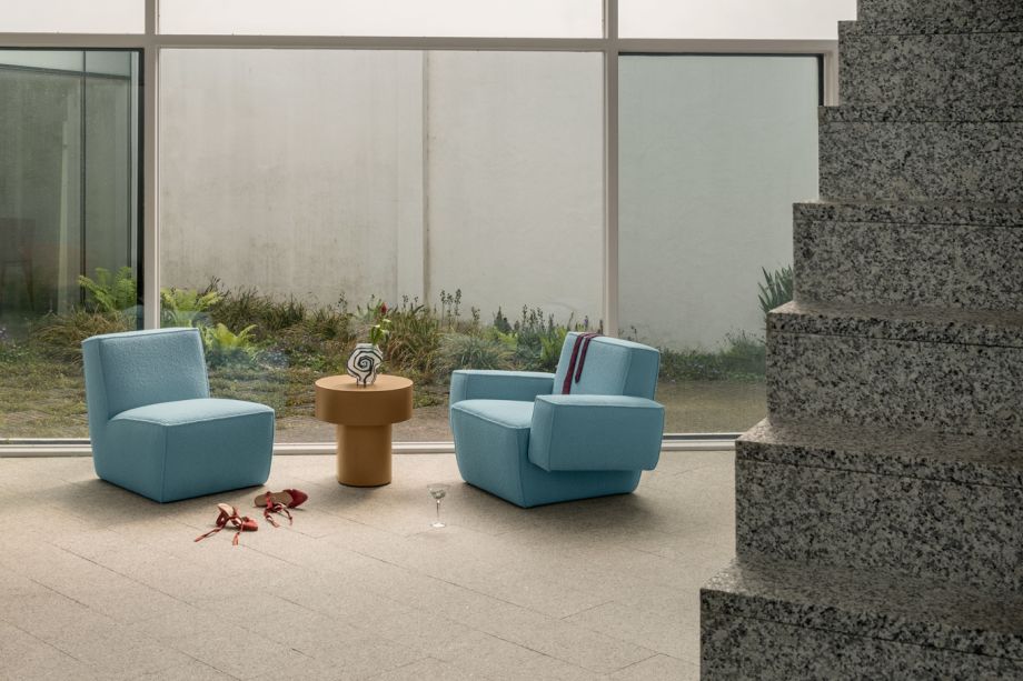 A lifestyle image of a lounge scene featuring Hunk Lounge Chair, Hunk Lounge Chair with Armrests, and Stump Side Table.