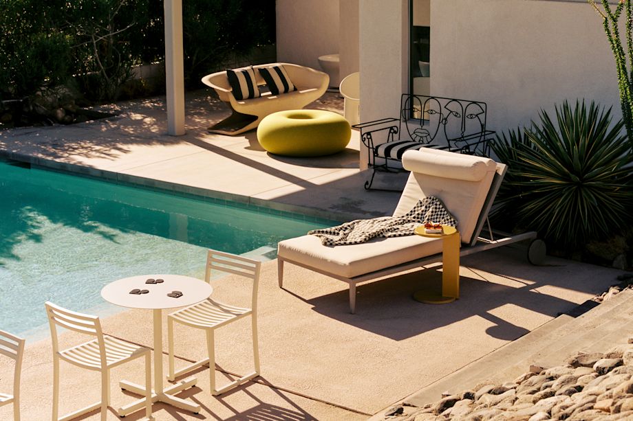 A lifestyle image of an outdoor lounge featuring Boa Pouf, Lolly Side Table, Chop Chairs (Set of 2), and Chop Table Round.