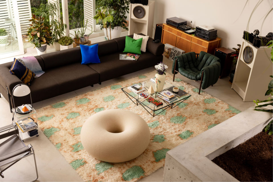 A lifestyle image of a living room scene featuring Boa Pouf, Monster Rug, Puffy Lounge Chair, Palo Modular Sofa, Velvet Cushion, and Crepe Cushions.