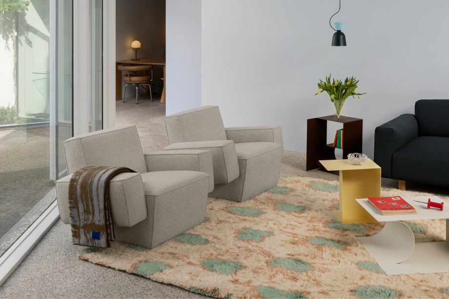 A lifestyle image of a living room / lounge featuring Hunk Lounge Chair with Armrests, Glitch Throw, Glyph Side Tables, Alphabeta Pendant Light, Monster Rug, and Koti 3-seater Sofa.