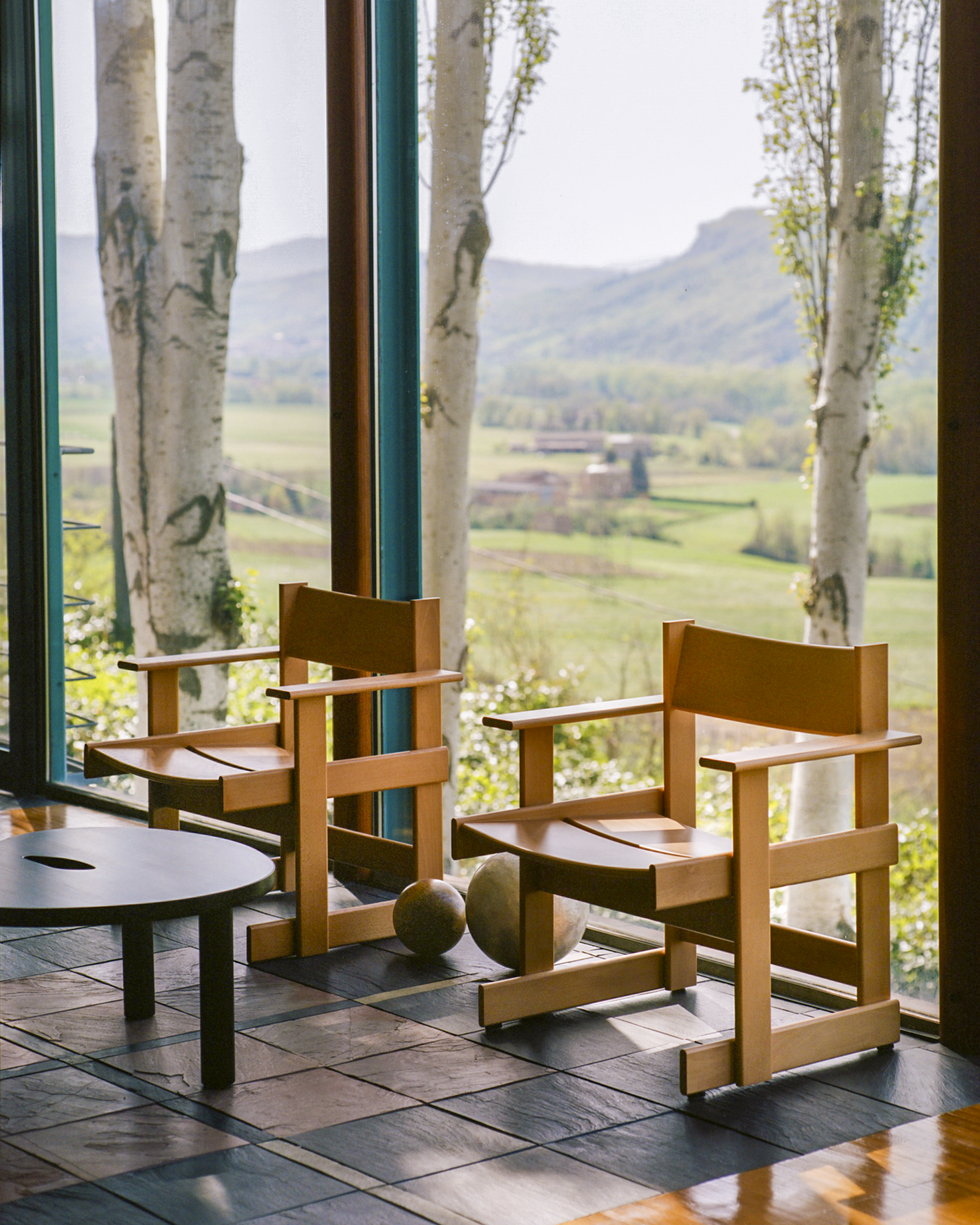 A lifestyle image of a lounge scene featuring Bullnose Lounge Chairs and Worm Table.
